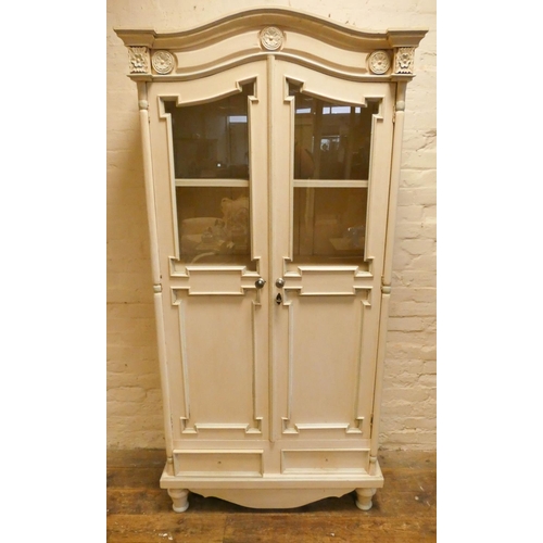 173 - A cream painted two door wardrobe with part glazed panel doors and interior shelves, 2'10 wide