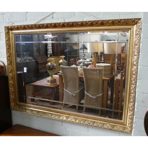 121 - A large bevelled wall mirror in decorative gilt frame