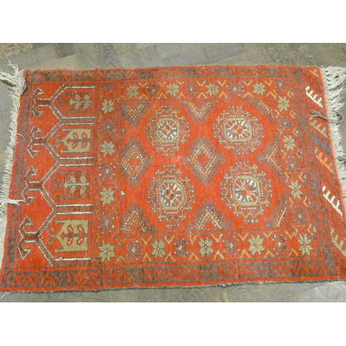 251 - A small red Bokhara pattern rug, 40