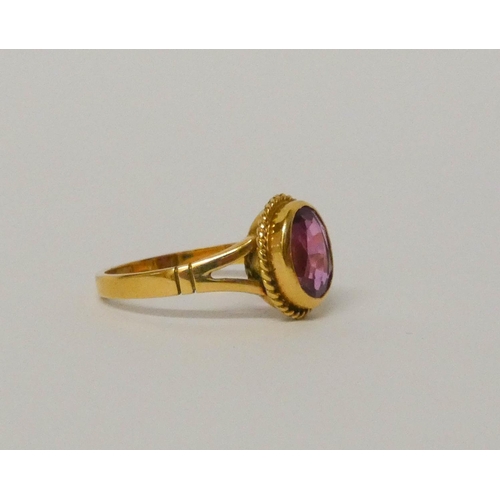 571 - 18ct yellow gold single stone pink sapphire ring, in oval rub over setting. Hallmarked ring size P