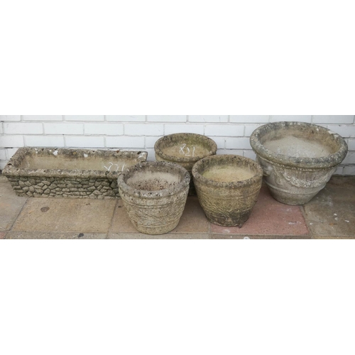 821 - Four circular reconstituted stone garden pots and one trough shaped garden pot...