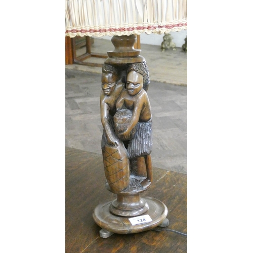 124 - A carved wooden African figural table lamp with raffia shade