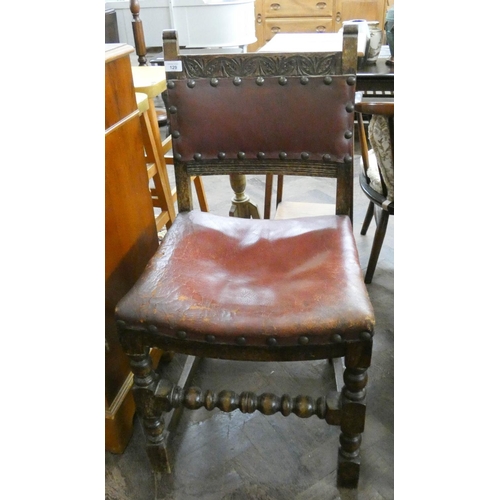 129 - A carved oak framed hall chair with leather seat and back