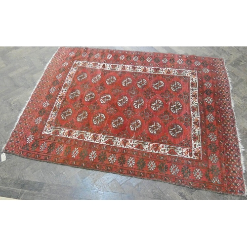 200 - A red woollen Persian rug measuring 6'3 x 4'6