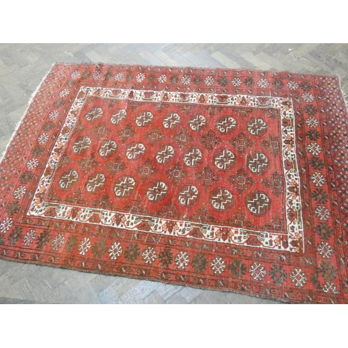 200 - A red woollen Persian rug measuring 6'3 x 4'6