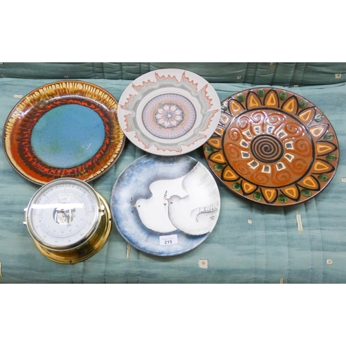 215 - A collection of four pottery wall chargers and a brass wall mounting ships barometer/thermometer