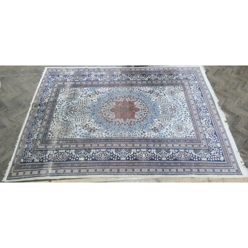 216 - A large cream and blue figured Persian design carpet measuring 9' x 6'