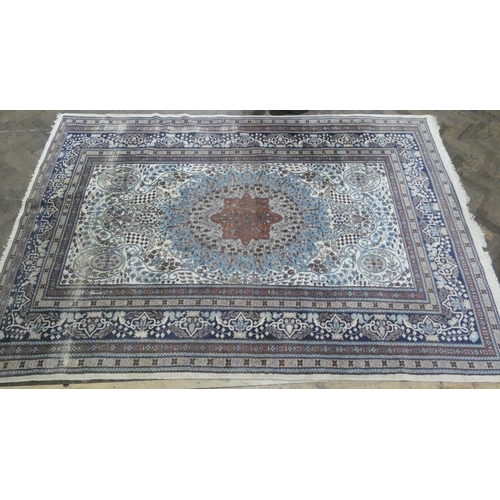 216 - A large cream and blue figured Persian design carpet measuring 9' x 6'