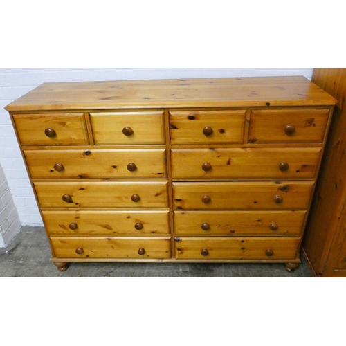 262 - A large varnished pine combination chest of eight long and four short drawers, all with turned bun h... 