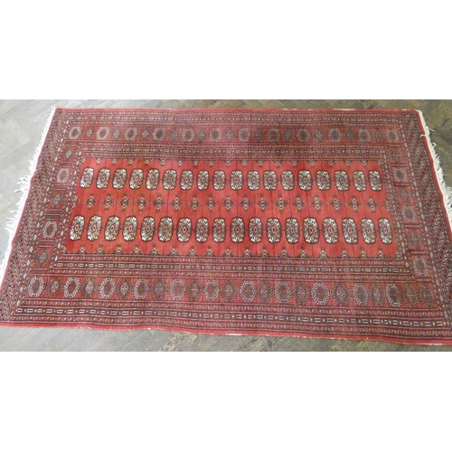 91 - A red and patterned Bokhara rug, 7' x 4'