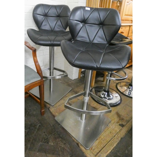 239 - A pair of padded black faux leather and stainless steel base kitchen stools