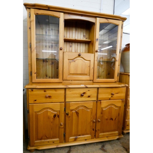 243 - A modern varnished pine kitchen dresser fitted two glazed doors with drinks cabinet to the centre on... 