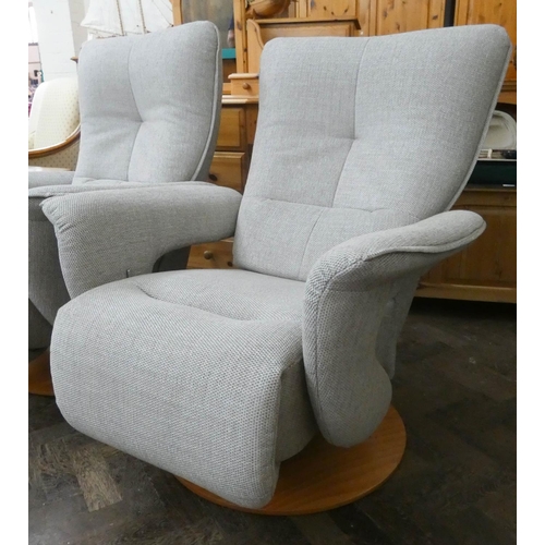 254 - A pair of modern Himolla swivel reclining easy chairs in a pale grey chenille