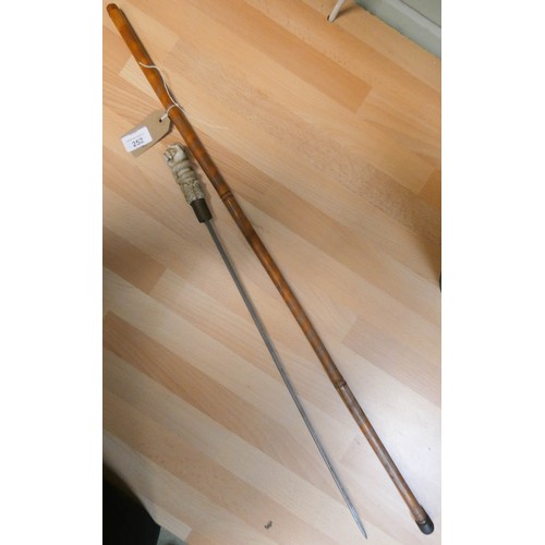 252 - A sword stick, in bamboo walking stick scabbard with oriental style resin handle modelled as a fist ... 