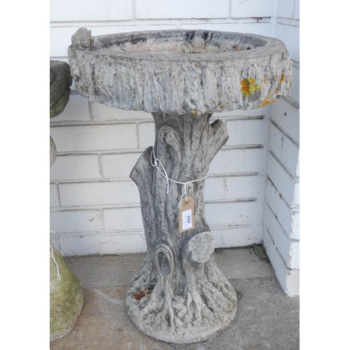 494 - A reconstituted stone garden bird bath modelled as a tree trunk with removable top decorated with a ... 