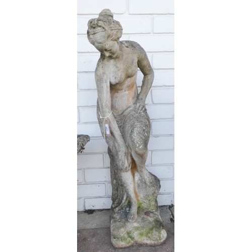 497 - A large weathered reconstituted stone garden ornament of a scantily clad female