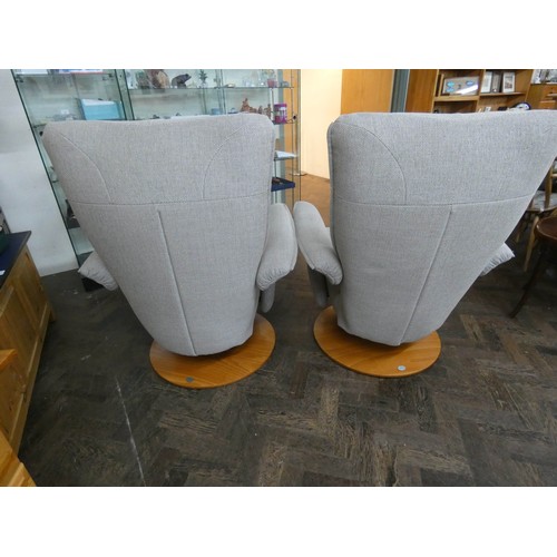 254 - A pair of modern Himolla swivel reclining easy chairs in a pale grey chenille