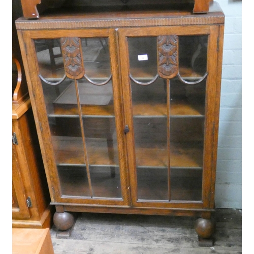 42 - A 1930's carved oak two door glazed fronted bookcase