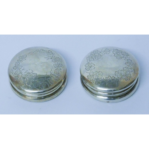 594 - A pair of silver circular pill boxes, with engraved floral decoration and gilded interiors, London 1... 