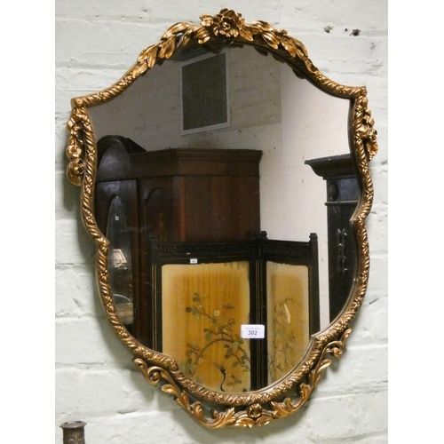 302 - A Victorian style gilt framed shaped wall mirror