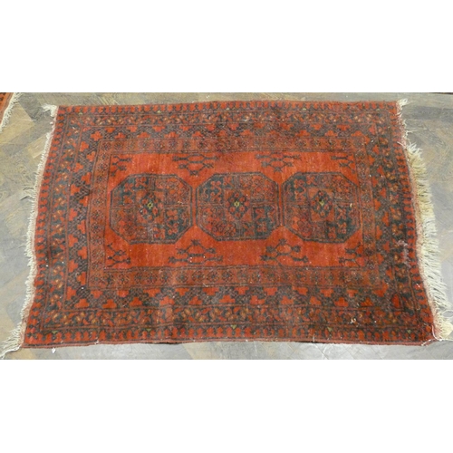 347 - A red and patterned Afghan wool pile rug, 58