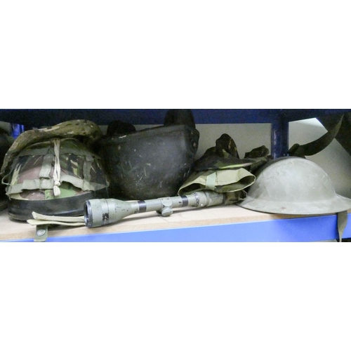 921 - Three assorted army helmets with some camouflage hats, ground sheet, stab vest, telescopic sight and... 
