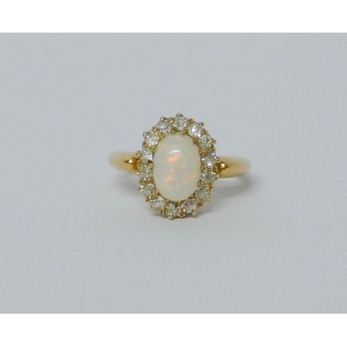 697 - Opal and diamond oval cluster ring, on yellow band, tests as 18ct, ring size I