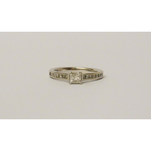 721 - A diamond engagement ring, set with a princess cut diamonds on diamond shoulders on platinum band, h... 