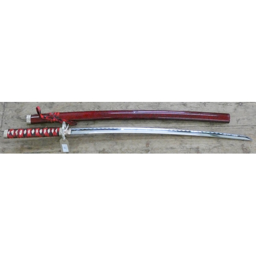 13 - A reproduction Japanese sword in scabbard...