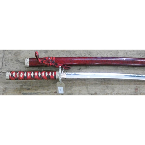 13 - A reproduction Japanese sword in scabbard...