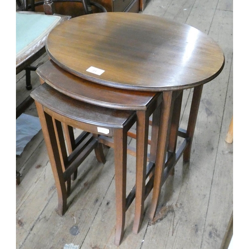 31 - A nest of three oval mahogany coffee tables...