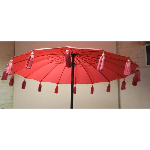 38 - A Chinese style floral garden parasol and a pink wind up Indian tasselled garden parasol...