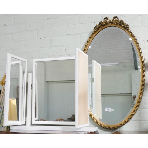 42 - An oval bevelled wall mirror in gilt frame together with a triple white dressing table mirror...