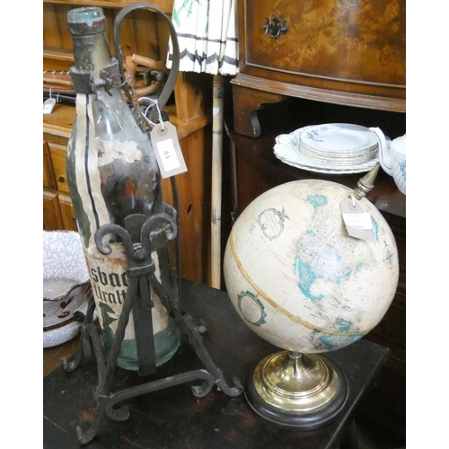 44 - A large wine bottle on an iron stand and a globe of the world...