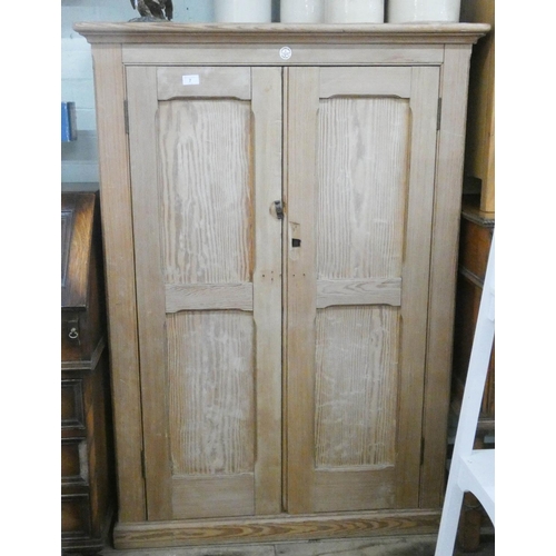 7 - A late Victorian stripped pine two door cupboard with interior shelves, bares label from the Educati...