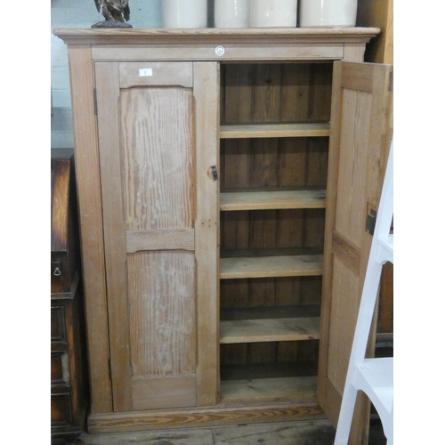 7 - A late Victorian stripped pine two door cupboard with interior shelves, bares label from the Educati...