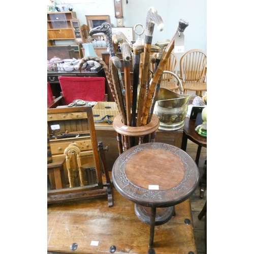 82 - A circular two tier carved occasional table and an umbrella stand