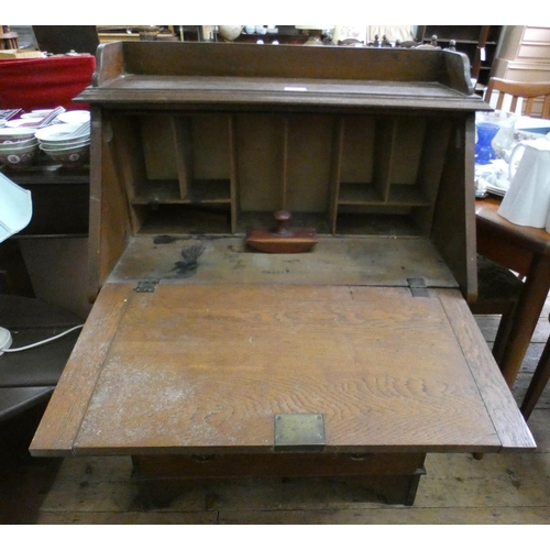 173 - An oak tray topped bureau with three long drawers under, 2'6 wide