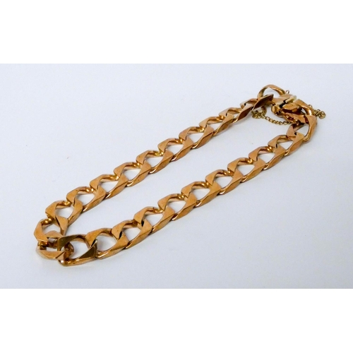 688 - 9ct gold flattened curb link chain gents bracelet, with clasp and safety chain fastening. Gross weig... 