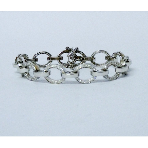 716 - A modern diamond open link bracelet, the oval 18ct white gold links channel set with diamonds, invis... 