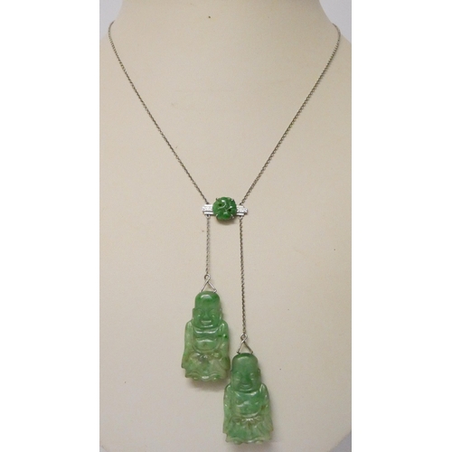 730 - An Art Deco carved jade asymmetric pendant necklace, in 9ct white gold, set with two carved jade Bud... 