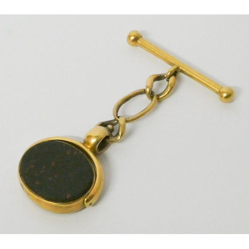 733 - A Victorian 18ct yellow gold carnelian swivel fob on curb chain and T bar. Both marked 18ct. Gross w... 