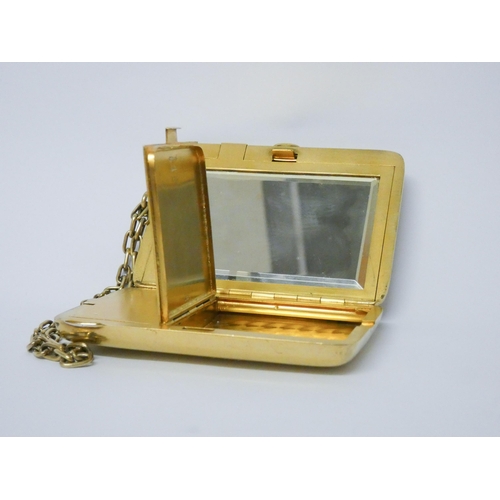 646 - A vintage American silver gilt ladies necessaire compact, suspended from a chain, with mirror, doubl...