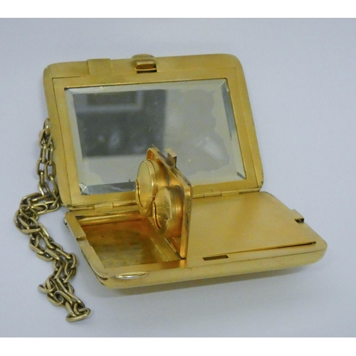 646 - A vintage American silver gilt ladies necessaire compact, suspended from a chain, with mirror, doubl...