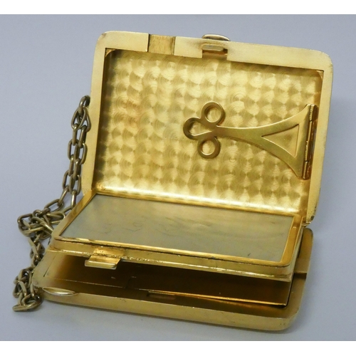 646 - A vintage American silver gilt ladies necessaire compact, suspended from a chain, with mirror, doubl...