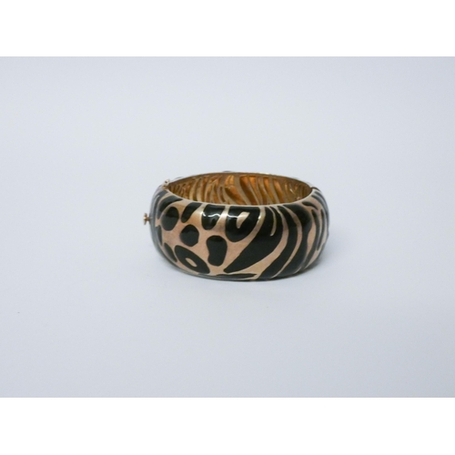 648 - A striking silver gilt and black enamelled bangle with animal print design. Hallmarked...