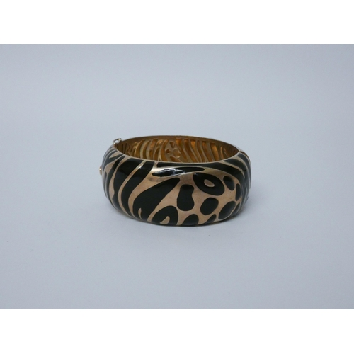 648 - A striking silver gilt and black enamelled bangle with animal print design. Hallmarked...