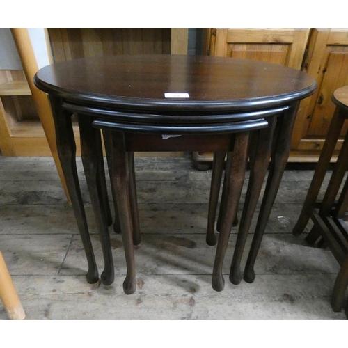 28 - A nest of three oval mahogany coffee tables on cabriole style legs...