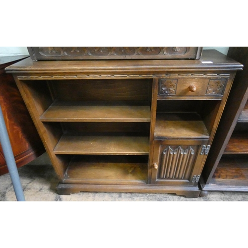 52 - A linen fold carved oak bookcase fitted shelves, drawer and cupboards, 3' wide...