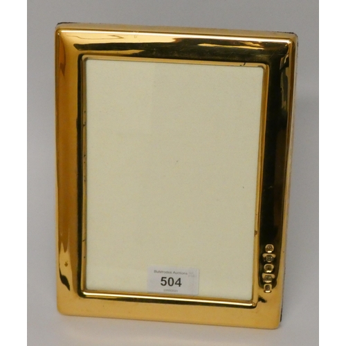 504 - A modern silver gilt rectangular easel photograph frame. 22cms tall